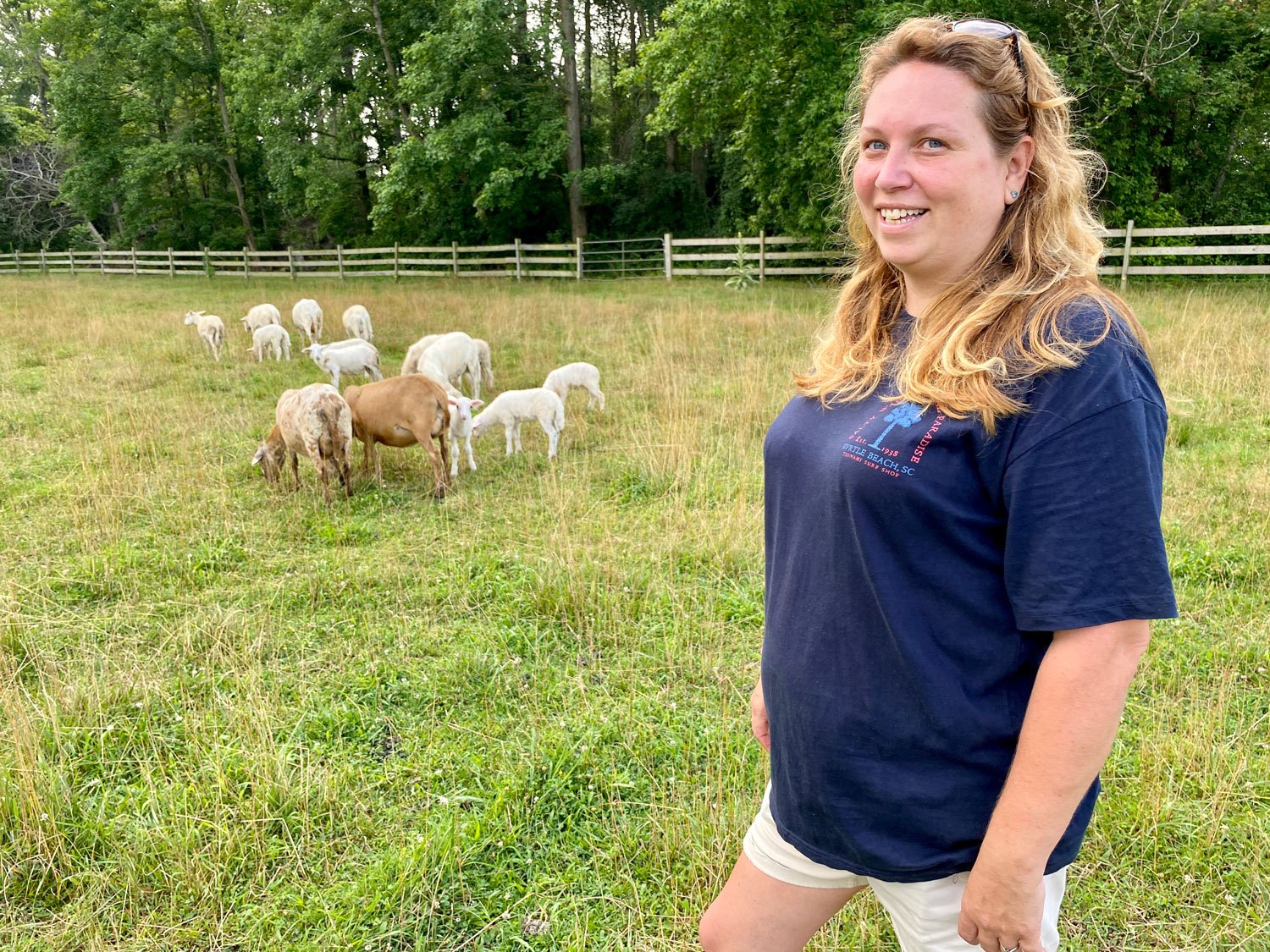Photo of Enoch Farms farmer with goats in her field