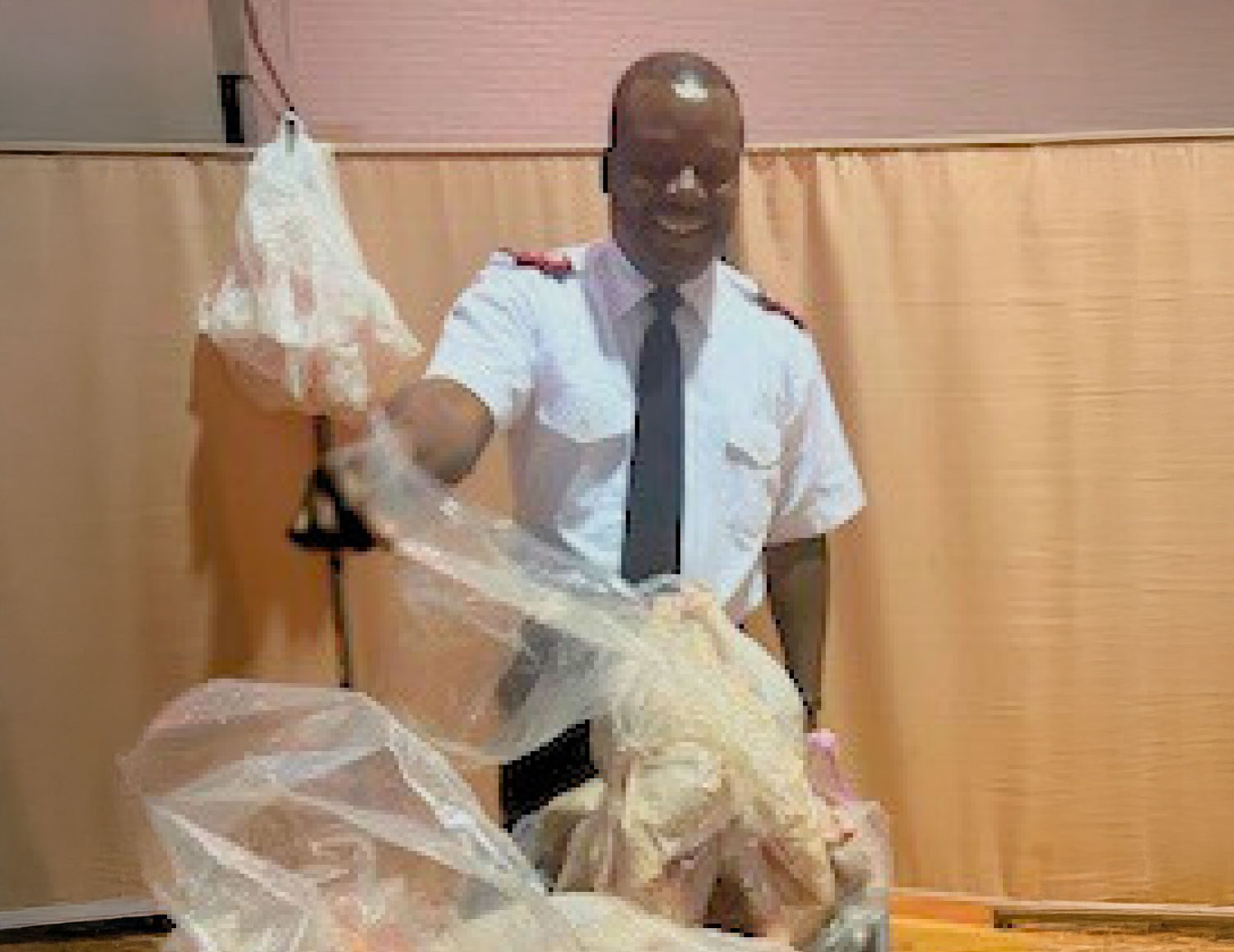 Man in uniform holding up a Turkey ready to be donated at the Salvation Army in Dover.