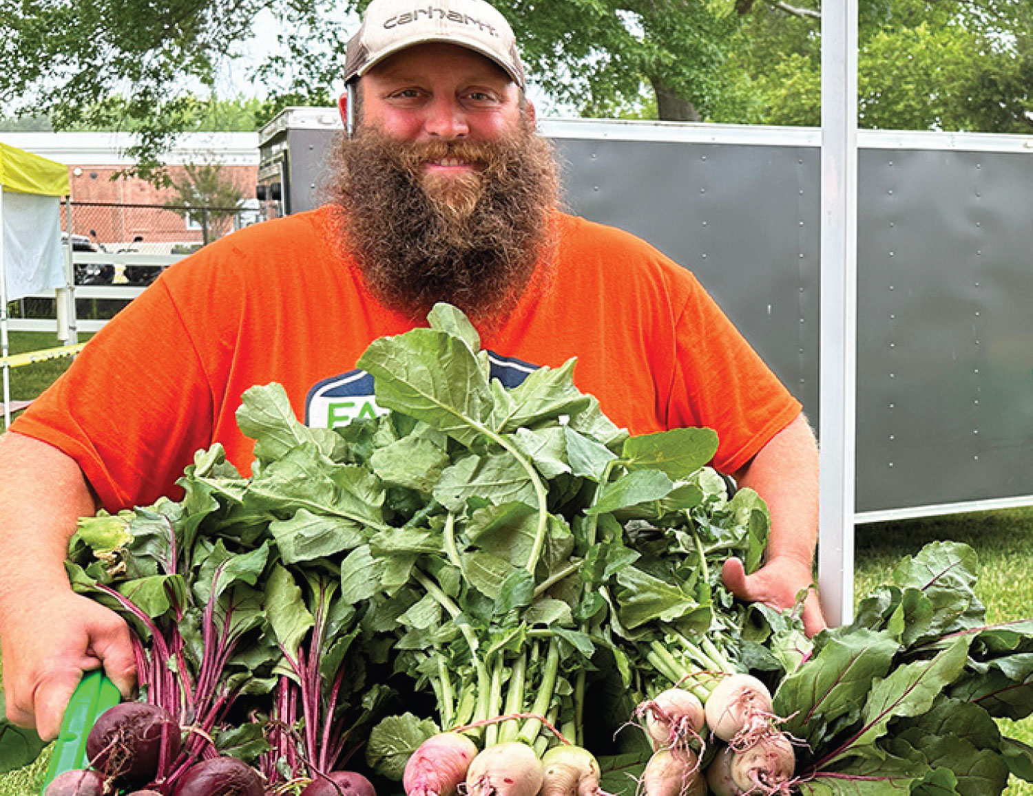 Dittmar Family Farms holdng up fresh beets and radishes for the community